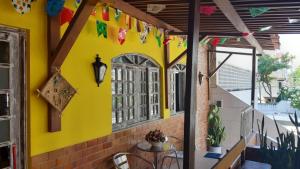 a patio with a yellow wall and a table and chairs at Piratas do Sol Hostel in Recife