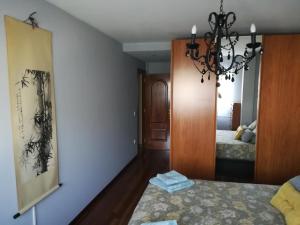 um quarto com uma cama e um lustre em Javi em Gijón