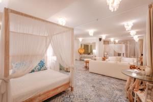 a bedroom with a canopy bed and a living room at Terrazza Plenilunio in Uluwatu