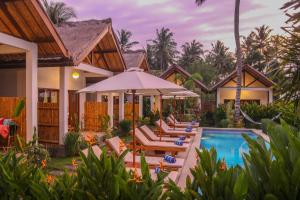 a villa with a swimming pool and a resort at Cozy Cottages Lombok in Senggigi