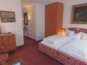 ein Hotelzimmer mit einem Bett und einer Kommode sowie einem Schlafzimmer in der Unterkunft Pension Am Museum in Glückstadt