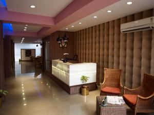 a lobby with a counter and chairs in a room at Comfort Hotels in Coimbatore