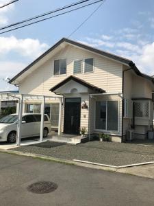 a house with two cars parked in front of it at F.stic＿house in Fuji