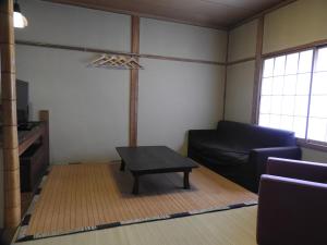 a living room with a couch and a coffee table at Hunter Lodge in Myoko