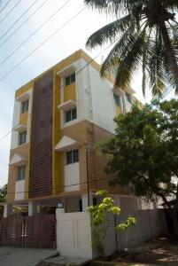 un edificio blanco y amarillo con una valla delante en Comfort`s Pearl, en Coimbatore