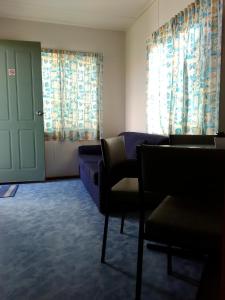a waiting room with chairs and a door and curtains at Beach Haven Caravan Park in San Remo