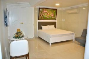 a bedroom with a bed and a table and a chair at Homestay coco in Vung Tau
