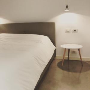 a bedroom with a white bed and a table at BLoft Charme&Relax in Bergamo +10 photos