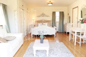 un soggiorno con un letto bianco e un divano bianco di Room for Two a Richmond