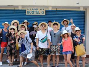 a large group of people standing next to each other at Hostel Q in Osaka