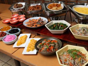 un tavolo con molti piatti diversi di cibo sopra di Hotel Tetora Otsu Kyoto a Otsu