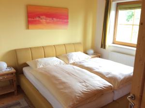 Bett in einem Zimmer mit Fenster in der Unterkunft Almhaus Karantanien in Hochrindl