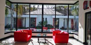a room with two red chairs and a table at 21 Kingfisher Guesthouse in Johannesburg