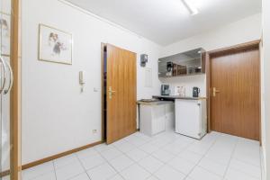 eine Küche mit einer Holztür und einem Kühlschrank in der Unterkunft Private Apartment in Hannover
