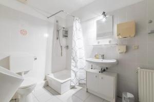 ein weißes Bad mit einem WC und einem Waschbecken in der Unterkunft Private Apartment in Hannover