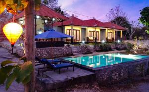 a house with a swimming pool in front of a house at Kampuak Cottages in Nusa Penida