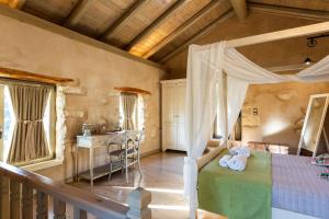 a bedroom with a canopy bed and a table at Vrisali Traditional Stone Villa in Yerolákkos