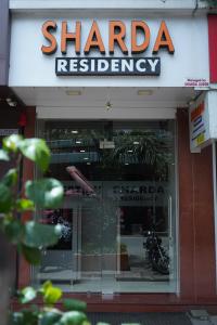 a sign for a sharia restaurant with a motorcycle in the window at Sharda Residency in Mumbai