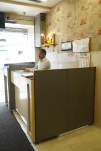 a man sitting at a counter in a fast food restaurant at Sharda Residency in Mumbai