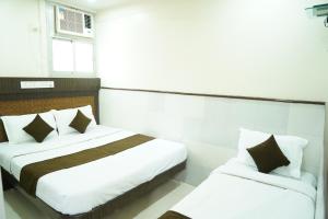 Sharda Residency tesisinde bir odada yatak veya yataklar