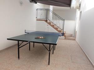 eine Tischtennisplatte in einem Zimmer mit einer Treppe in der Unterkunft Apartments Sunce in Brna