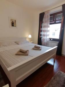 1 cama blanca grande con 2 toallas en Studio apartment Zagorka Tkalčićeva street en Zagreb