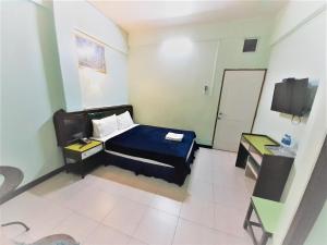 a bedroom with a bed and a desk and a television at Singapore Hotel in Hat Yai