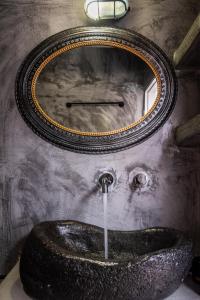 a bathroom with a sink with a clock on the wall at Sunset Nest in Plaka Milou +13 photos