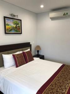 een slaapkamer met een wit bed en een foto aan de muur bij Hanoi Monaco Building 801 in Hanoi