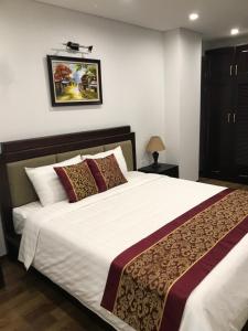 een slaapkamer met een groot bed met witte lakens bij Hanoi Monaco Building 801 in Hanoi