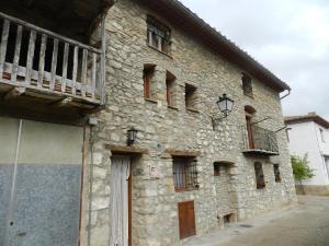 un edificio de piedra con un balcón en un lateral. en Casa Enduella en Morella