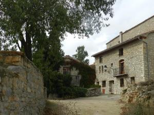 un antiguo edificio de piedra junto a una pared de piedra en Casa Enduella, en Morella