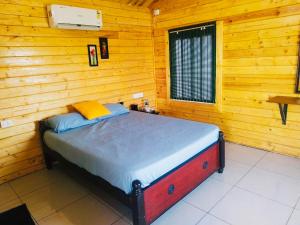 sypialnia z łóżkiem w drewnianym pokoju w obiekcie Bleu & Blanc w mieście Puducherry