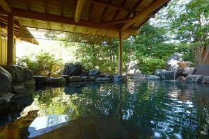 una piscina de agua en un patio con rocas en Tatsumikan, en Minakami