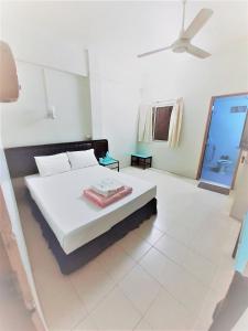1 dormitorio blanco con 1 cama con techo en Singapore Hotel, en Hat Yai