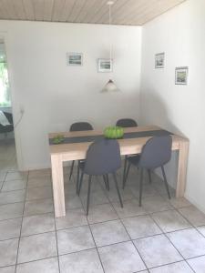 a dining room with a wooden table and chairs at Det Bette Hus in Hjørring +7 photos