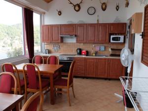 una cocina con armarios de madera, mesa y sillas en Apartments Sunce en Brna