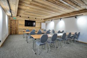 sala konferencyjna ze stołami i krzesłami oraz ekranem projekcyjnym w obiekcie LISA-Chalets w mieście Flachau