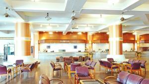 a lobby with tables and chairs in a building at Pattaya Park Beach Resort in Pattaya South