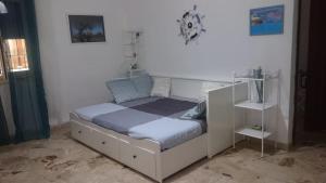 ein Schlafzimmer mit einem Bett mit einem weißen Bettrahmen in der Unterkunft Vacanzasicilia in Porto Empedocle