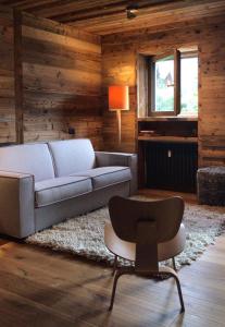 uma sala de estar com um sofá e uma cadeira em Dolomiti Dreams em Selva di Val Gardena