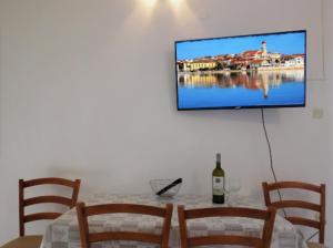 un tavolo con una bottiglia di vino e una televisione su una parete di Charming apartment Karlo a Betina