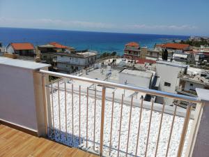 a balcony with a view of the ocean and buildings at Crystal Blue Apartments in Nea Kalikratia