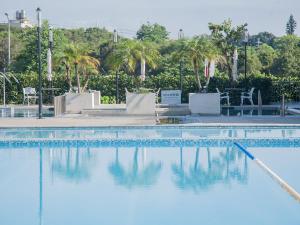 una piscina con agua azul y palmeras en Freshfields Hotel, en Wuri