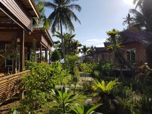 um jardim em frente a uma casa com palmeiras em Mook Montra Resort Sea Front em Ko Mook
