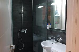 Un baño con ducha, lavabo y espejo. en Your Home in Tbilisi: Cosy stay in the Old City, en Tiflis 7 fotos más