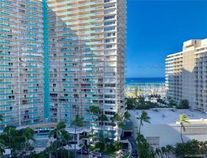 an aerial view of a large building with palm trees and the ocean at Waikiki vacation 2BR suite 88 in Honolulu