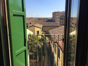 ein Fenster mit grüner Tür und Stadtblick in der Unterkunft Appartamento Guercino in Cento