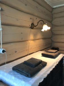 2 serviettes assises sur une étagère dans un sauna dans l'établissement Ligedama Wabatalu, à Koljaku