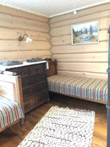 1 dormitorio con 2 camas, vestidor y alfombra en Ligedama Wabatalu, en Koljaku